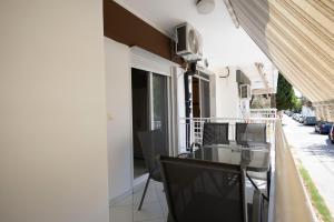 a balcony with a table and chairs on a building at Nearby the sea in Asprovalta
