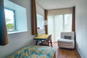 a bedroom with a bed and a desk and a chair at Cottage des Cerisiers in Lens