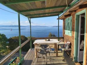 a deck with a table and chairs and a view of the ocean at Fitalmios in Methana