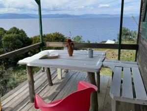 a table and chairs on a deck with a view of the ocean at Fitalmios in Methana +12 photos