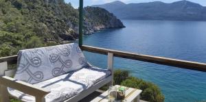 a bench sitting on a balcony overlooking a body of water at Fitalmios in Methana