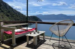 a balcony with a bench and a table and a chair at Fitalmios in Methana