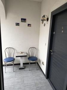 two chairs and a table in a room with a door at Casa Dorului in Mangalia