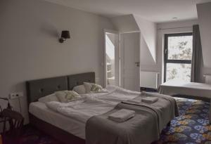 a bedroom with a bed with two towels on it at Początek Jutra in Pajewo