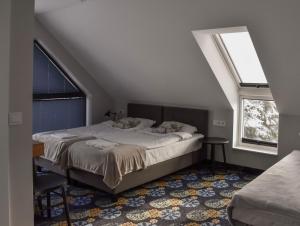a bedroom with a bed and two windows at Początek Jutra in Pajewo