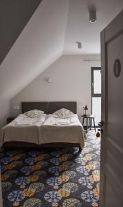 a bedroom with a bed and a rug at Początek Jutra in Pajewo