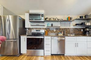 a kitchen with stainless steel appliances and white cabinets at Shorelands Resort Cottage 40 in Kennebunk