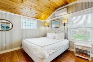 a bedroom with a white bed and a wooden ceiling at Shorelands Resort Cottage 40 in Kennebunk +35 photos