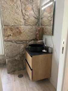 a bathroom with a sink and a stone wall at Casa De Cantoneiros in Campos +31 photos