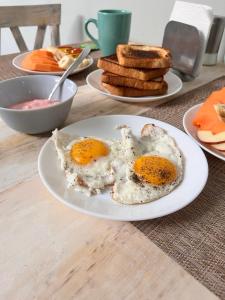 two eggs on a plate on a table with toast at Hotel Casa 22 in San Miguel de Allende