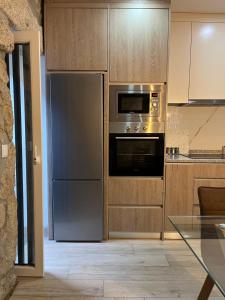 a kitchen with a stainless steel refrigerator and microwave at Casa De Cantoneiros in Campos