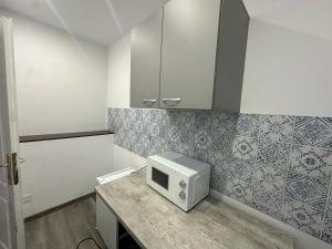 a kitchen with a microwave sitting on a counter at LuxInn in Bucharest +39 photos