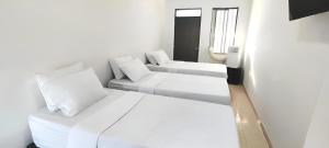 ein weißes Zimmer mit zwei Betten und einer Couch in der Unterkunft Hotel San Rin in Nilo + 23 Fotos
