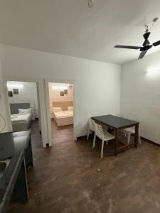 a room with a table and chairs and a bedroom at Sunshine Park By RoomzAway in Candolim +36 photos