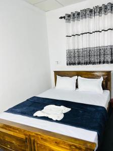a bedroom with a bed with a wooden headboard at Livora Mountain Lodge in Etimole +5 photos