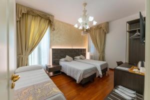 a hotel room with two beds and a chandelier at Villa Bellini Room&Breakfast in Porto Garibaldi