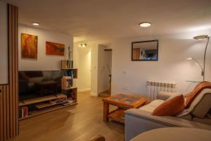 a living room with a couch and a flat screen tv at Refugio 1900 in San Cristóbal de Segovia