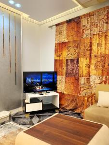 a living room with a large screen tv and a couch at Kemet Pyramids Apartments in Cairo