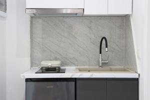 a kitchen with a sink and a stove and aaucet at Aura boutique hotel in Vlorë