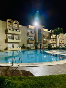 a large swimming pool in front of a building at night at Coin de Mire in Hammam Sousse
