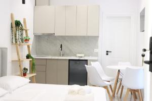 a kitchen with white cabinets and a table and chairs at Aura boutique hotel in Vlorë +49 photos