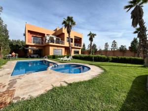 a villa with a swimming pool in front of a house at Villa isouktan in Sbiti