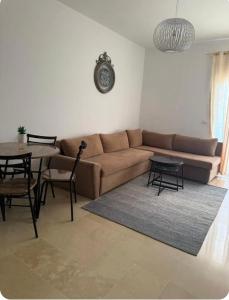 a living room with a couch and a table at Coin de Mire in Hammam Sousse +3 photos