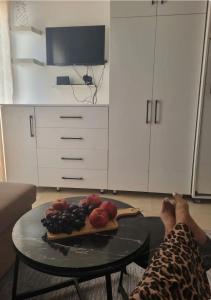 a person laying on the floor in a living room with a table with fruit at Coin de Mire in Hammam Sousse