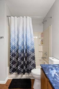 a bathroom with a toilet and a shower curtain at Quiet Avon Retreat in Indianapolis +61 photos