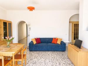 a living room with a blue couch and a table at Casa Lagò Lagò Panoramic Apartment in Ranzanico