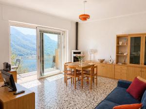 a living room with a table and a large window at Casa Lagò Lagò Panoramic Apartment in Ranzanico