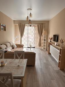 a living room with a couch and a large window at Luxury Residence Likani in Borjomi