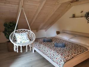 a bedroom with a bed and a swinging chair at Chalet Pasečná Apartments in Přední Výtoň +17 photos