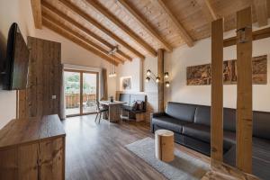 a living room with a couch and a television at Chalet Schaller in Missiano