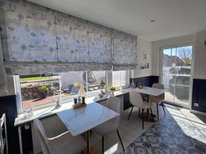 a kitchen with tables and chairs and a large window at Pension Zur Brandung in Büsum