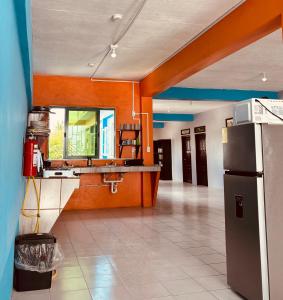 a kitchen with a sink and a refrigerator at Caye Caulker Hostel in Belize City +18 photos
