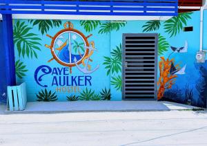 a blue building with a painting of a house at Caye Caulker Hostel in Belize City