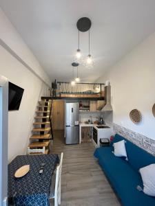 a living room with a blue couch and a kitchen at AJ studios by the Sea in Kithnos
