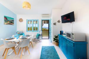 a living room with a table and chairs and a tv at Blue View - A Due Passi dal Mare & Natura in Quartu SantʼElena