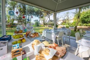 a table with food on it in a room with windows at Villa Bellini Room&Breakfast in Porto Garibaldi