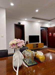 a white vase with flowers in a living room at KP Home in Xuân Trach