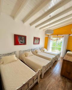 a group of four beds in a room at BARRIO VIEJO in Los Reartes