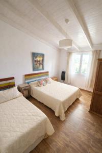 a bedroom with two beds and a window at BARRIO VIEJO in Los Reartes