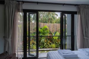 a bedroom with a sliding glass door to a patio at Aranya Bliss Villa 104 in Wok Tum +31 photos