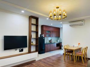 a living room with a television and a dining room at KP Home in Xuân Trach