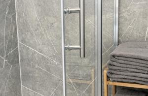 a shower with a glass door with a pile of towels at Royans Ferienwohnung in Günzburg +62 photos