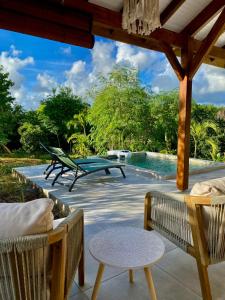 a patio with a table and chairs and a pool at Kôsy in Grand-Bourg
