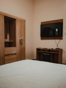 a bedroom with a bed and a flat screen tv at Hotel Star Rio in Novo Airão