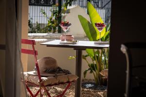 a table with a chair and two glasses on it at Villa Moments - Guest House in Portimão