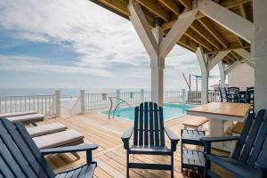 a deck with chairs and a table and a swimming pool at Saltwater Blessing by Oak Island Accommodations in Oak Island
